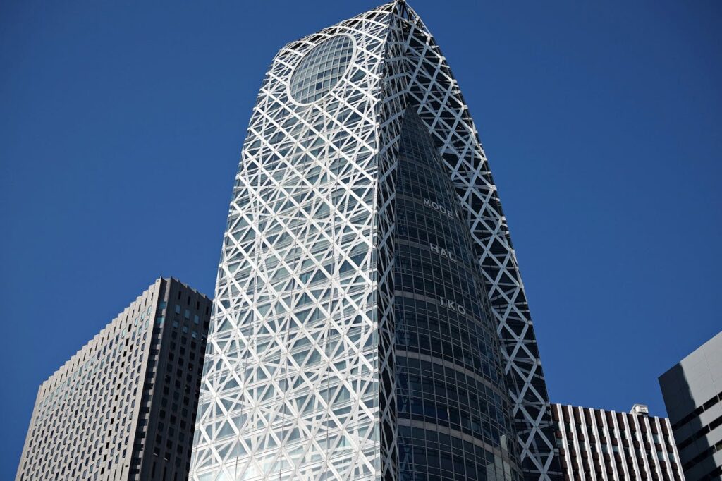 Modern architectural marvel, Mode Gakuen Cocoon Tower amidst Tokyo skyscrapers.
