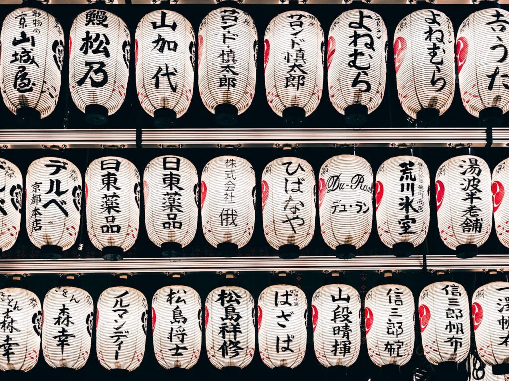 Detailed view of traditional Japanese paper lanterns with kanji characters, creating a cultural ambiance.