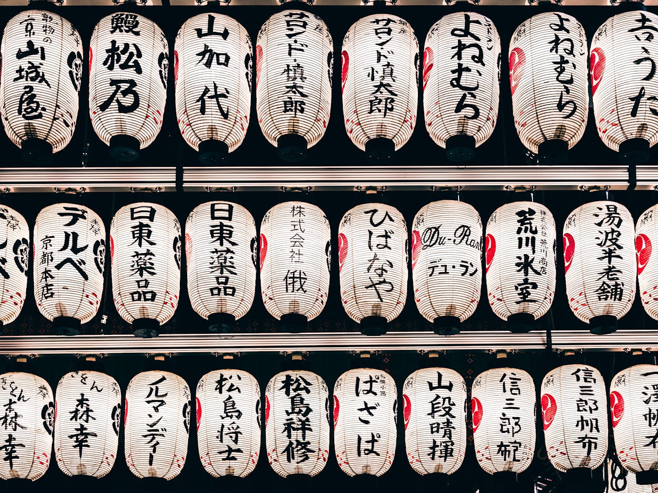 Detailed view of traditional Japanese paper lanterns with kanji characters, creating a cultural ambiance.